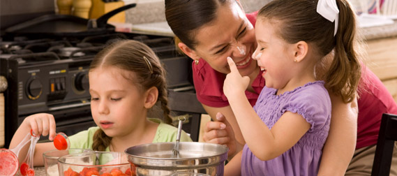 Mother with daughters in kitchen cooking